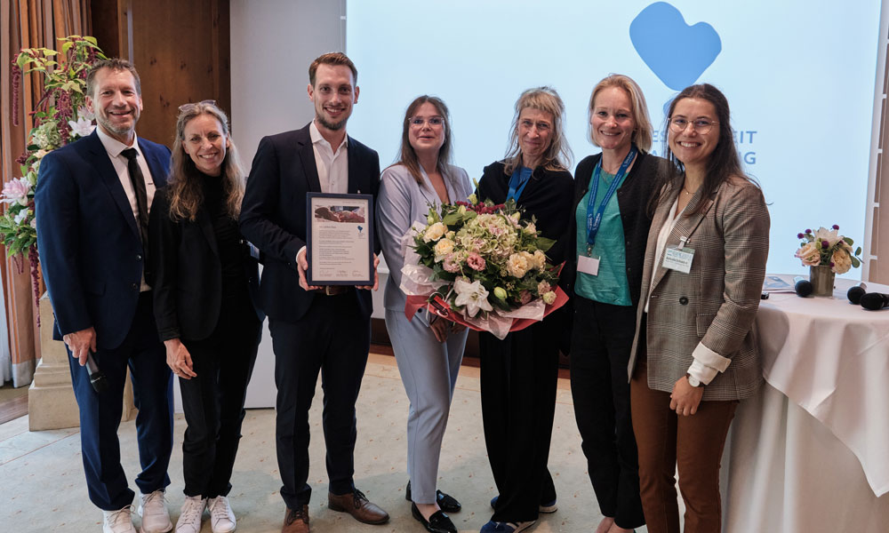 Überreichung der Urkunde durch den Stiftungsvorstand Prof. Dr. Dr. Kai Zacharowski und Carolina Lohfert Praetorius an das Preisträgerteam Dr. Urs Mücke, Anna-Lena Herbach, Petra Tiroke, Sabrina Sähn und Antonia Scheelen