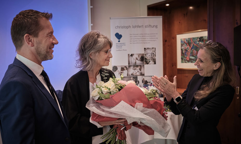 Stiftungsvorstand Prof. Dr. Dr. Kai Zacharowski und Carolina Lohfert Praetorius überreichen der Schirmherrin Dr. Regina Klakow-Franck einen Blumenstrauß