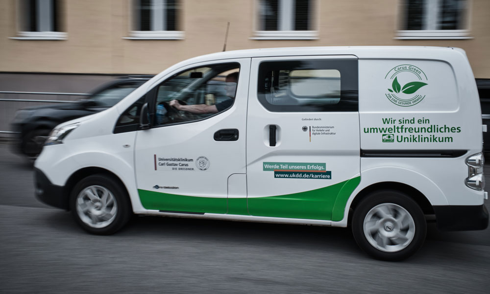 Elektromobilität: mehrere Nissan e-NV200 sowie Opel e-Movano kommen für den innerbetrieblichen Transport zum Einsatz. Insgesamt ersetzen mittlerweile 15 vollelektrische Fahrzeuge ausgediente Verbrenner – das entspricht einem Fünftel aller Fahrzeuge. Außerdem betreibt das UKD einen VW e-Up der den Pflegenden des Brückenteams für den Einsatz im Stadtgebiet dient sowie einen VW ID3.